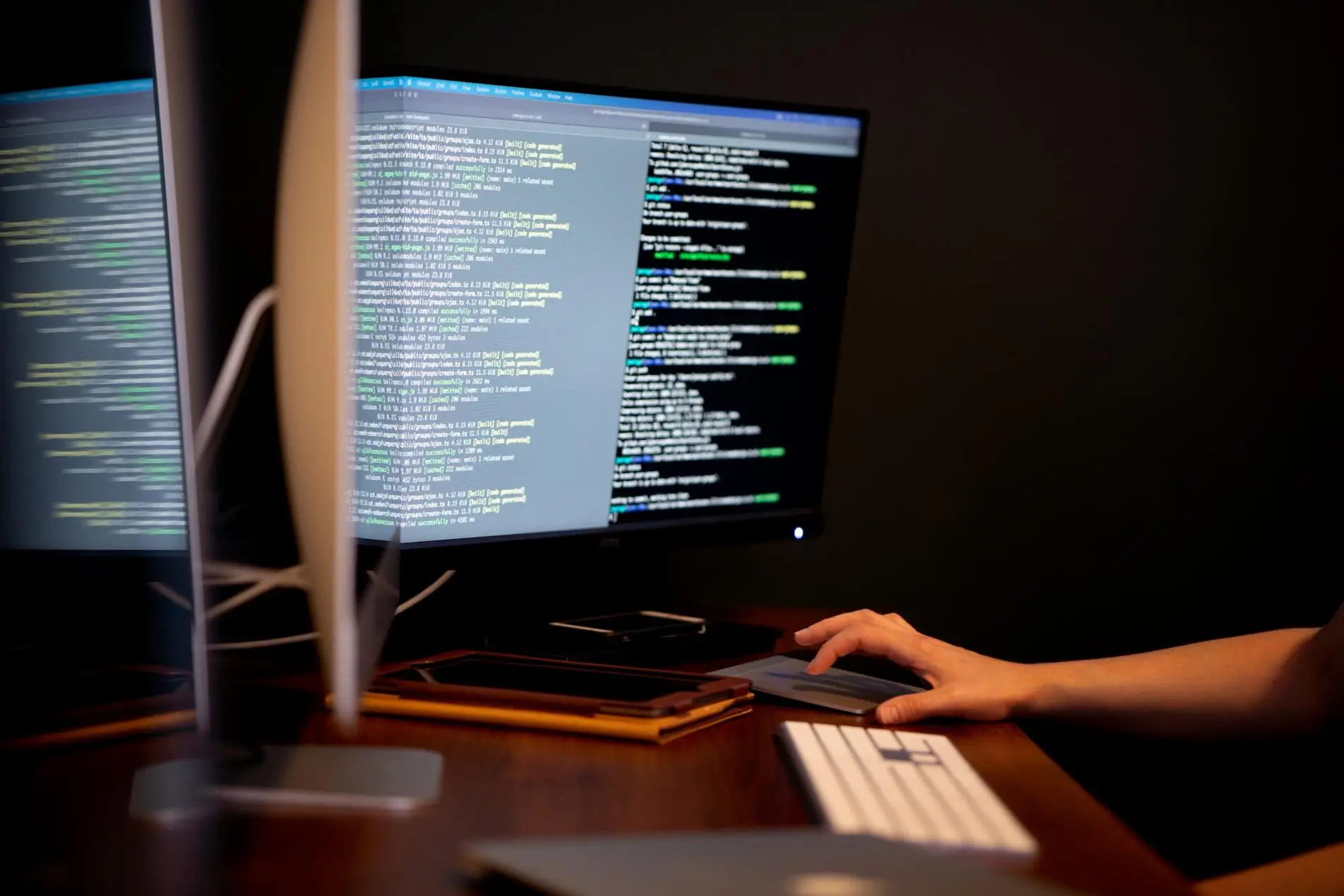 Person working on dual monitors with code, representing Brisk Agency, a website design agency in Exeter and London.